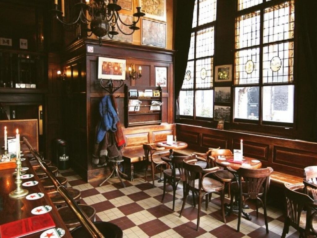 Interior of a cosy brown café with wooden tables, soft lights and locals chatting
