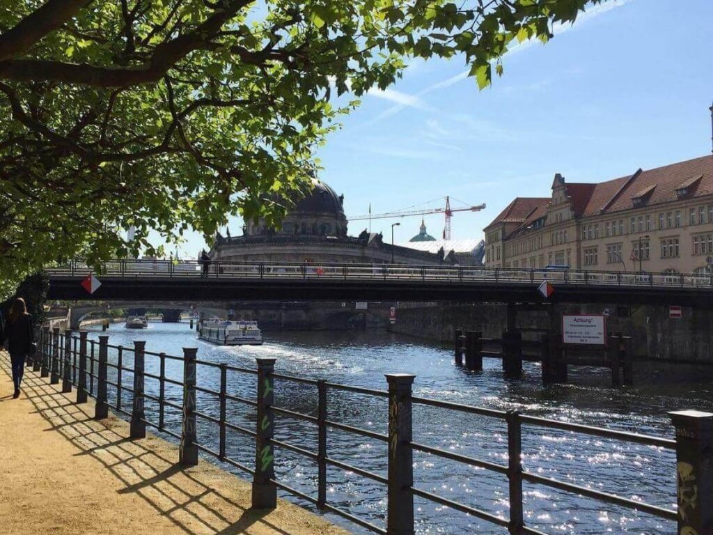 East Side Gallery murals along the Berlin Wall at sunset with reflections on the Spree River