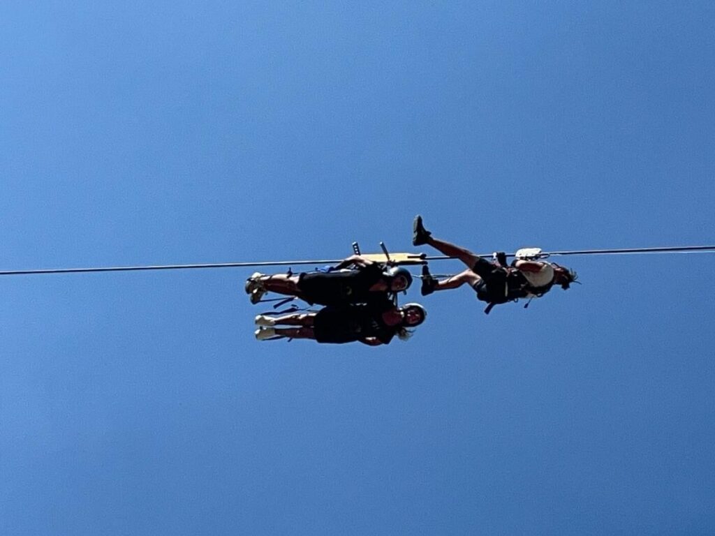 Person mid-zipline over the valley during the Flight of the Angel between Castelmezzano and Pietrapertosa.