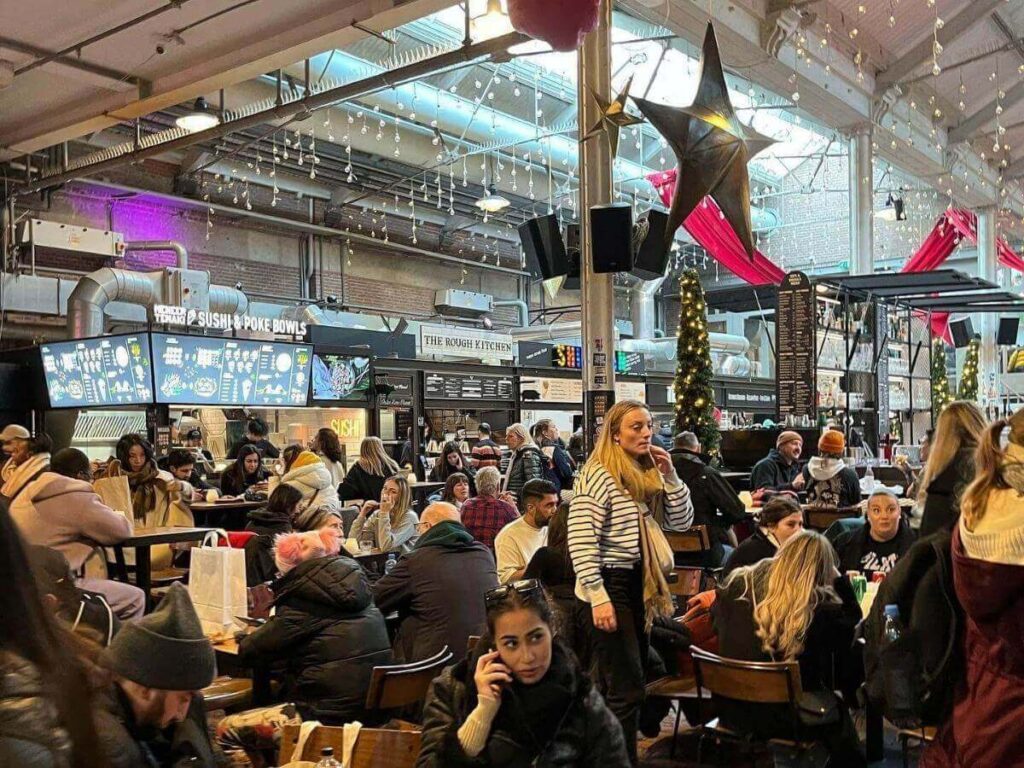 Busy Foodhallen food market with stalls and a variety of small dishes on display
