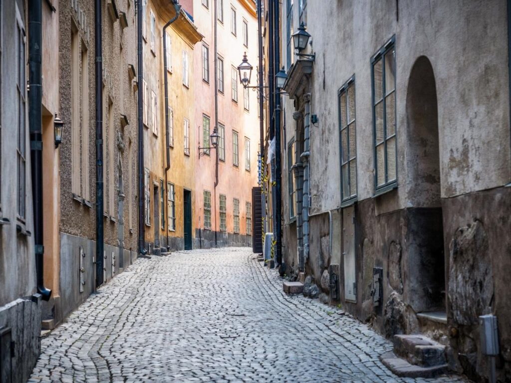 Early morning in Gamla Stan with empty cobblestone lanes and ochre buildings.