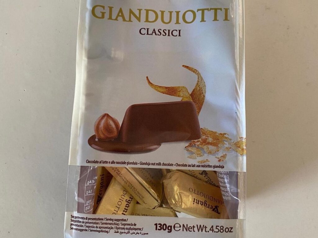 Gianduiotti chocolates wrapped in gold foil arranged in a box.