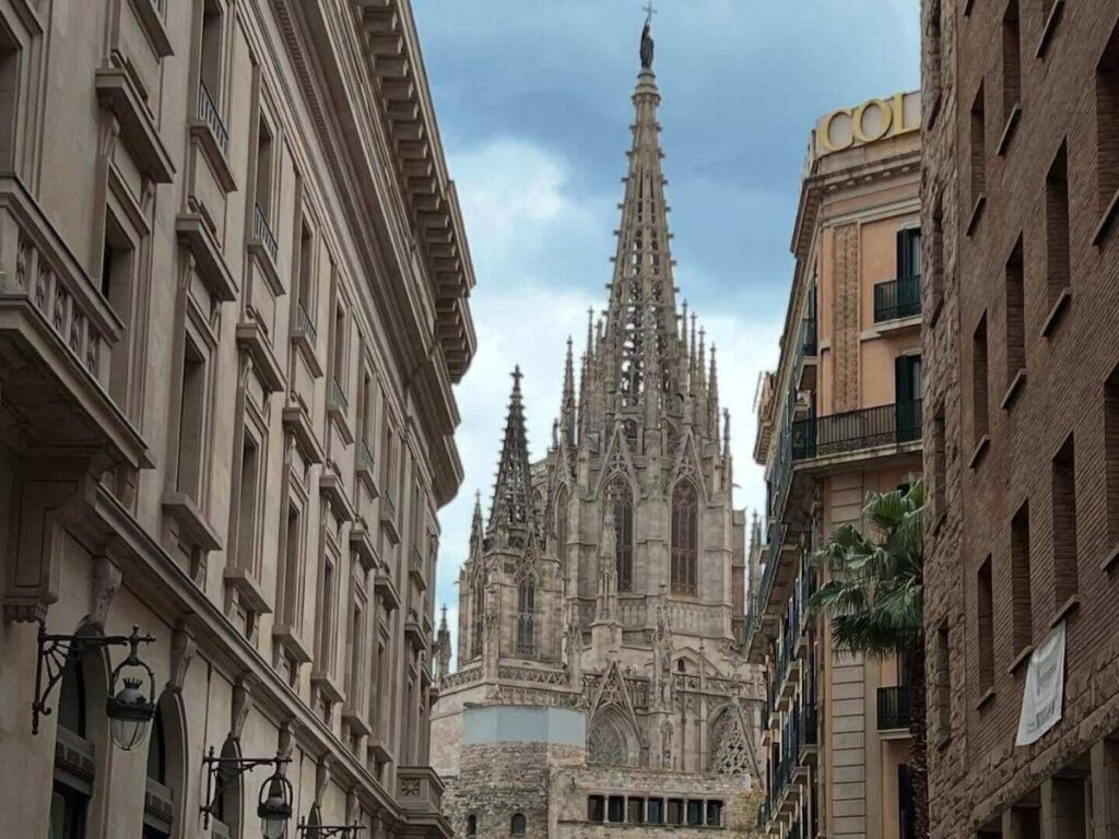 “Balcony view over a sunlit square in the Gothic Quarter