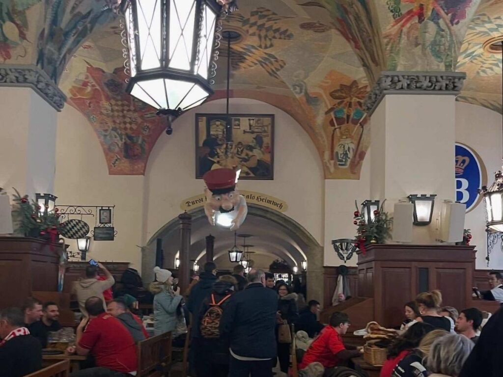Long wooden tables and packed interior of Hofbräuhaus with waitstaff