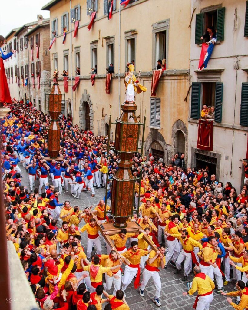 Crowd watching the Festa dei Ceri in Gubbio as participants carry the wooden candles through the streets