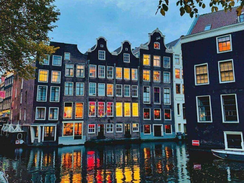 Close-up of a steaming coffee cup and a fresh stroopwafel on a napkin at a canal-side café