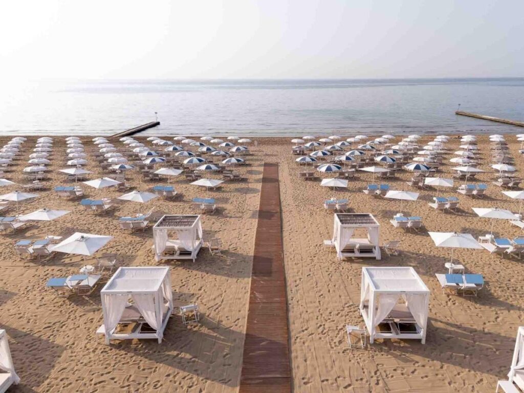 Reserved parasol with a name tag at a private stabilimento balneare in Jesolo.”