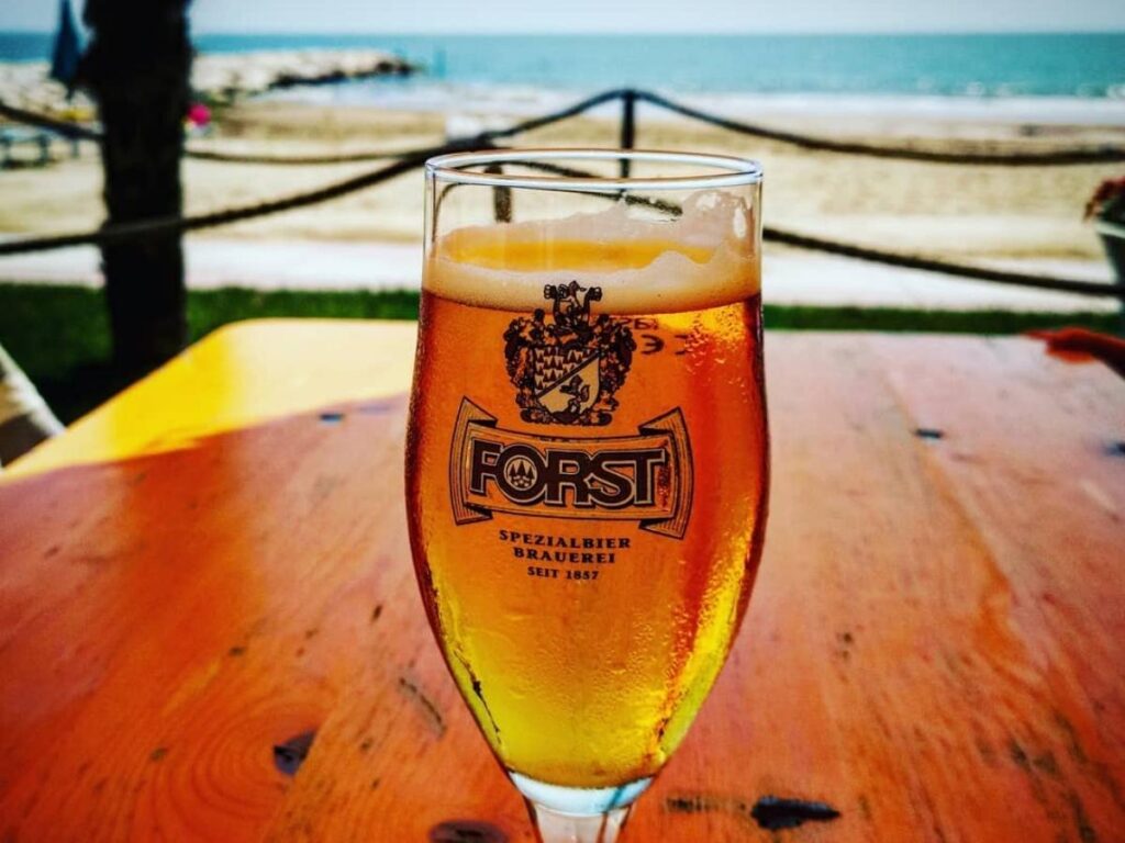 Small beach kiosk near the pier serving ice-cold beers and sandwiches at dusk.