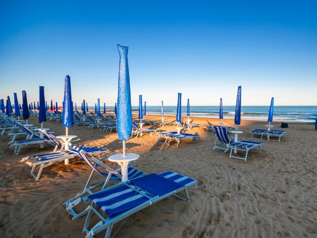 “Towel and folded umbrella on a quieter spiaggia libera public stretch in Jesolo.”