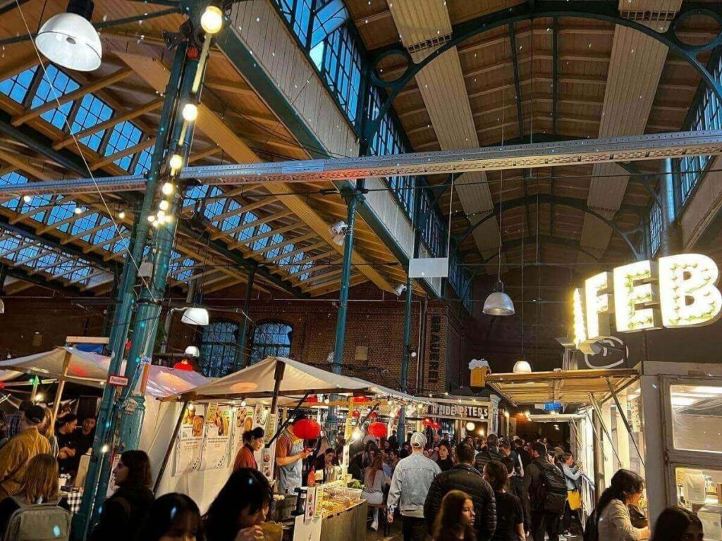 “Food stalls and neon lights at a night market in Kreuzberg, Berlin.