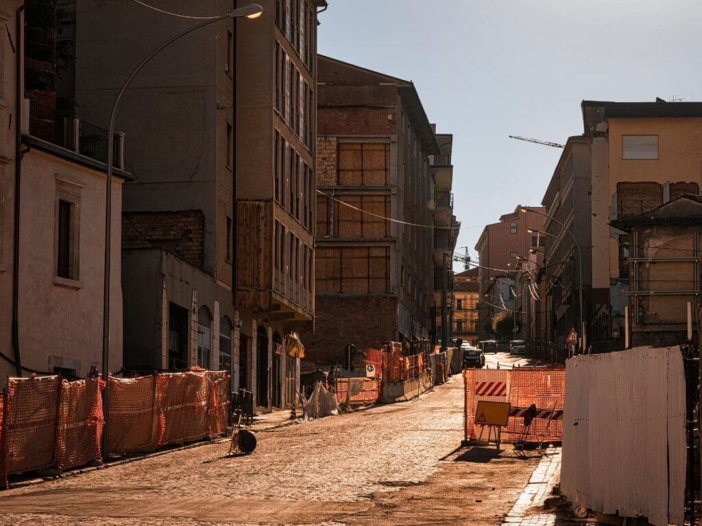 Close-up of saffron threads on a wooden spoon and saffron crocus fields in the background near L’Aquila.