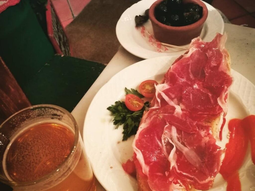 Friends sharing tapas and wine in a lively bar in La Latina, Madrid