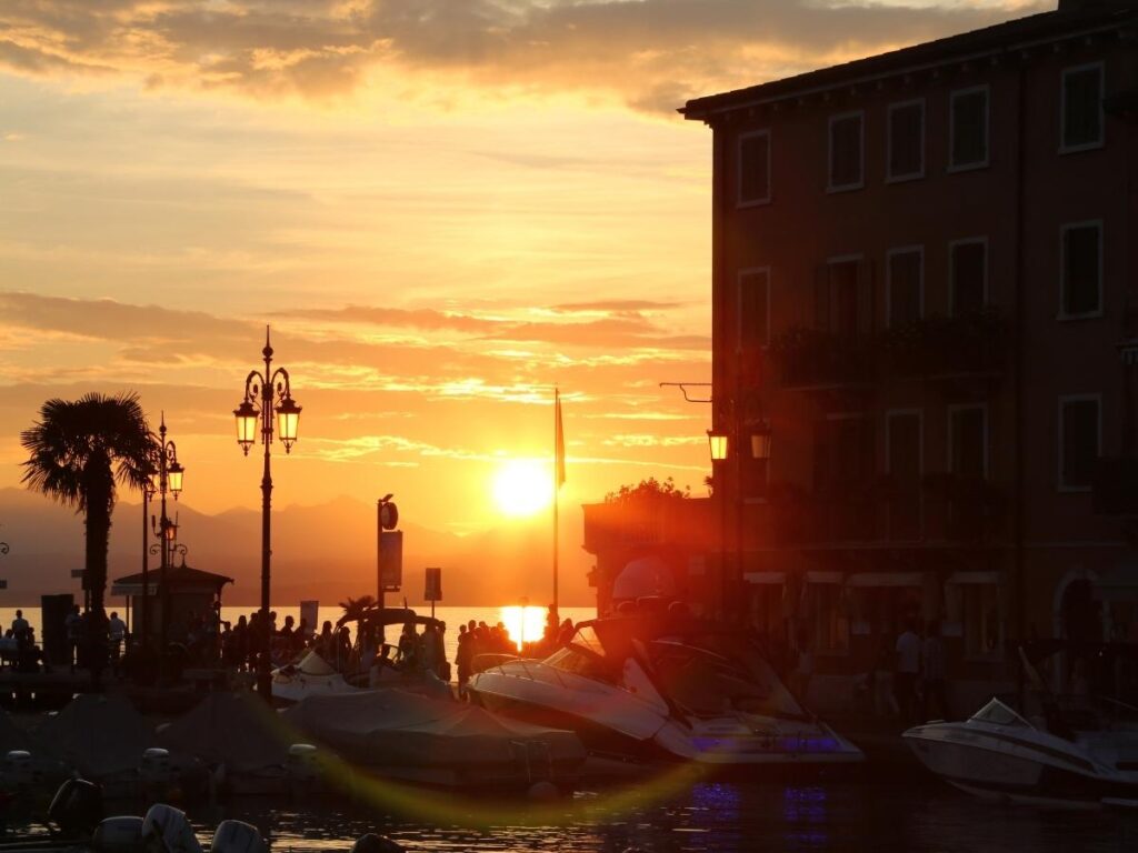 Lakeside hotel terrace in Lazise with breakfast table overlooking Lake Garda at sunrise