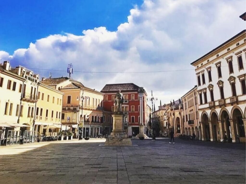 Person holding a gelato outside a small gelateria in Piazza Vittorio Emanuele, Lazise
