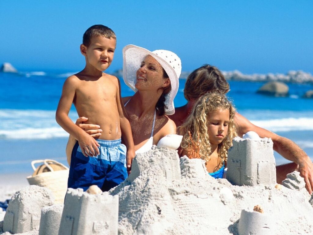 Family building sandcastles on a shallow Lignano beach