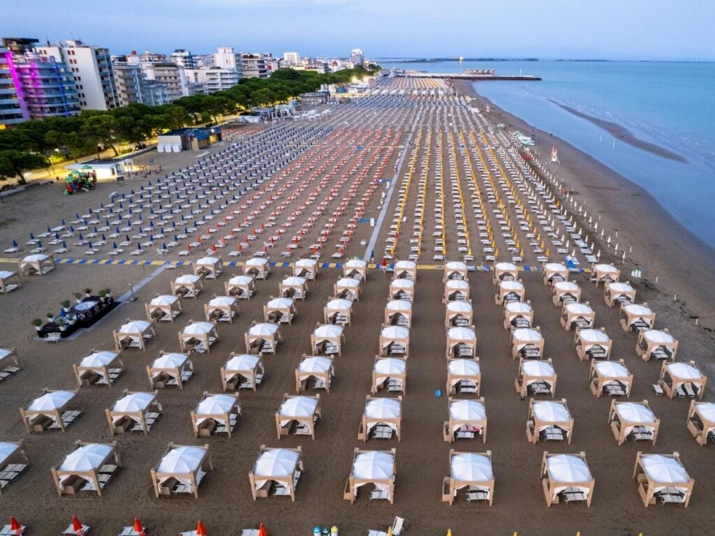 Aerial view of Lignano Sabbiadoro's golden beach and umbrellas at midday