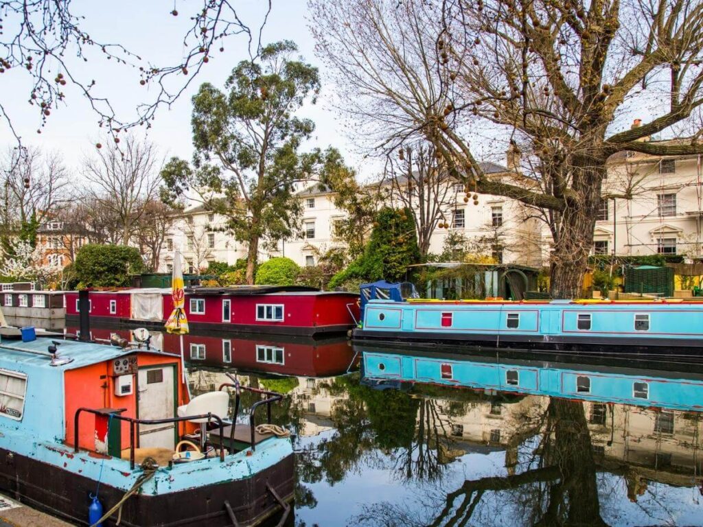 Colorful narrowboats moored at Little Venice in London beside canalside cafés
