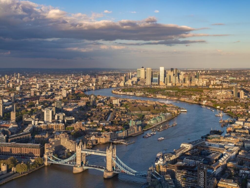 Evening view along the Southbank in London with Big Ben and the Thames glowing at sunset.