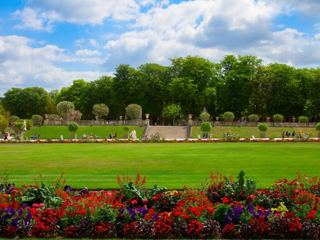 “Person reading on a green chair under the trees in the Luxembourg Gardens, Paris