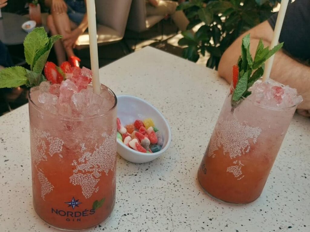 Cocktails at a rooftop bar overlooking Gran Vía at sunset in Madrid