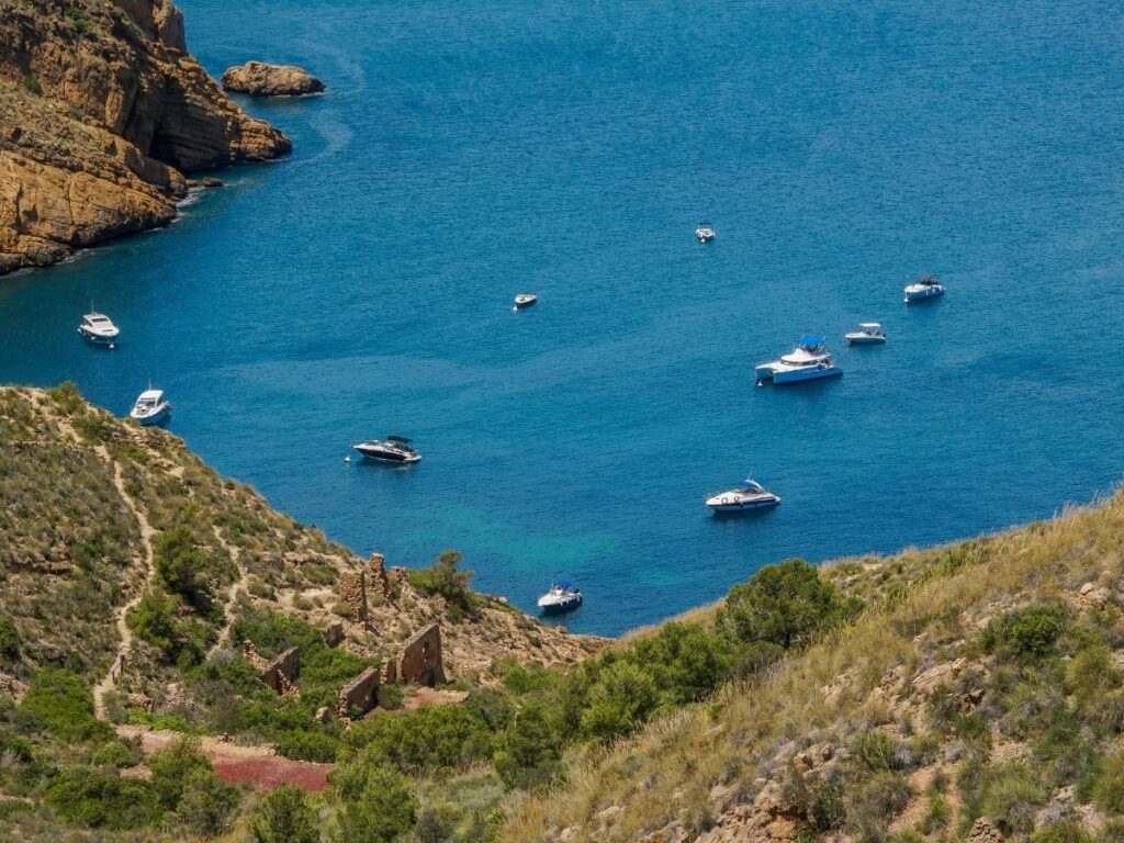 Small boat anchored in a turquoise cove along Maratea’s rocky coastline