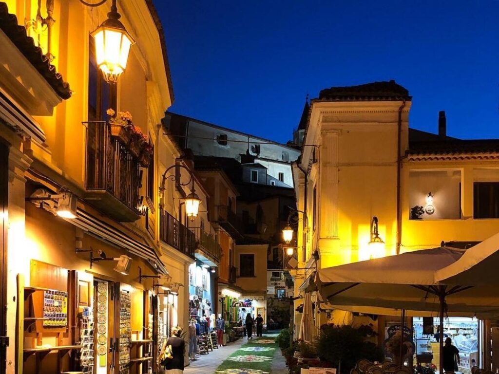Maratea’s old town at night with lantern-lit alleys and outdoor seafood restaurants.