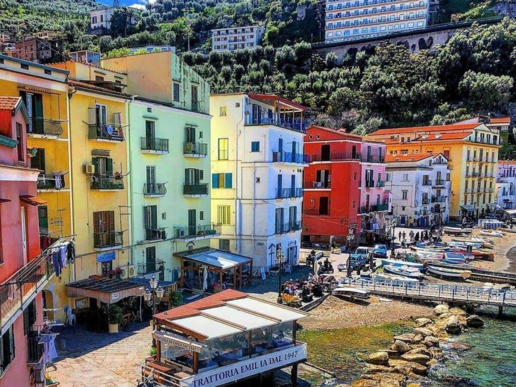 Colorful seaside buildings and small hotels lining Marina Grande with boats anchored nearby