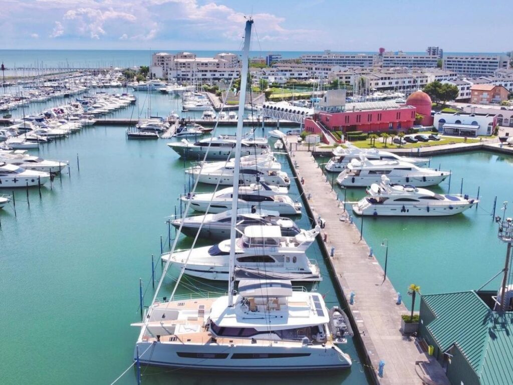 Yachts and boats moored at Marina Punta Faro at golden hour.