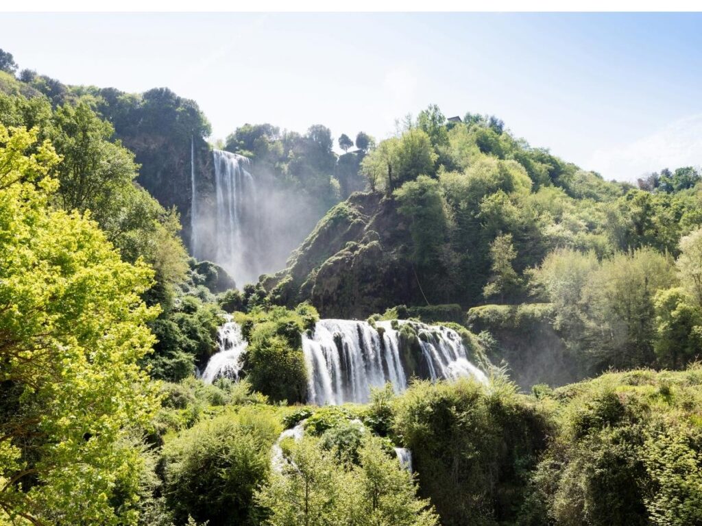 Marmore Falls in full flow, water cascading down rocky cliffs with visitors at the viewpoint