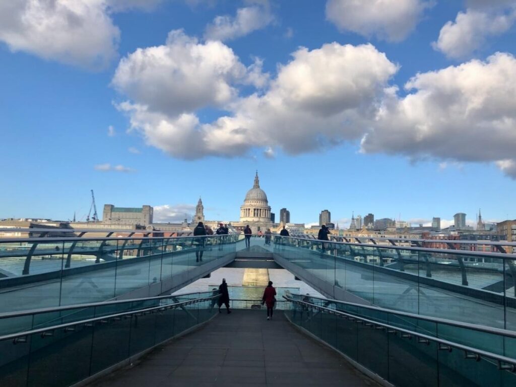 Pedestrians walking across Millennium Bridge with St Paul’s Cathedral in the background