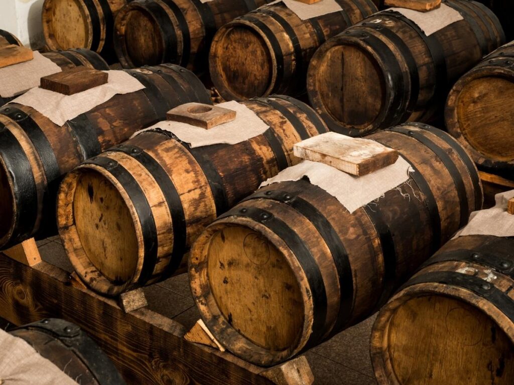 Rows of wooden barrels aging traditional balsamic vinegar inside an acetaia in Modena