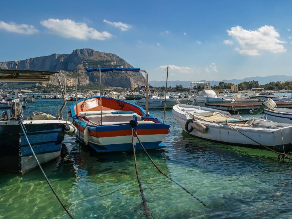 Turquoise water and beach cabins at Mondello Beach near Palermo with Monte Pellegrino in view