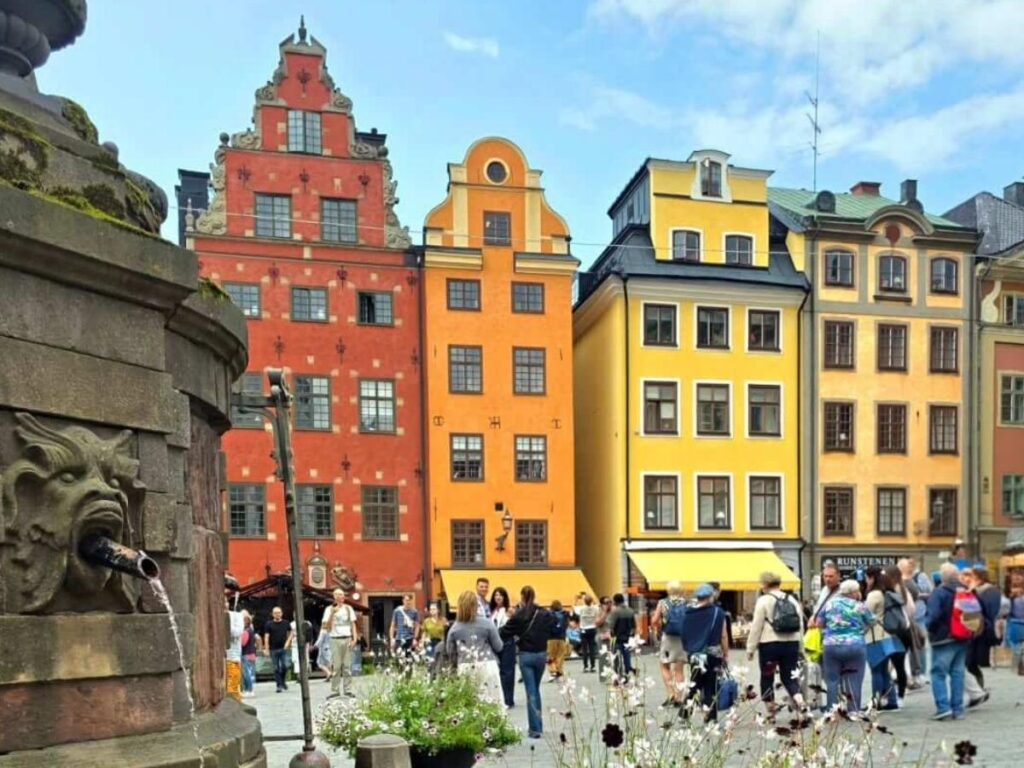 Narrow cobbled alley in Gamla Stan with ochre façades and soft morning light