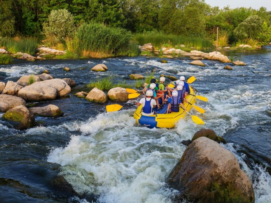 Hot air balloon floating over rolling Umbrian hills and Assisi at sunrise.