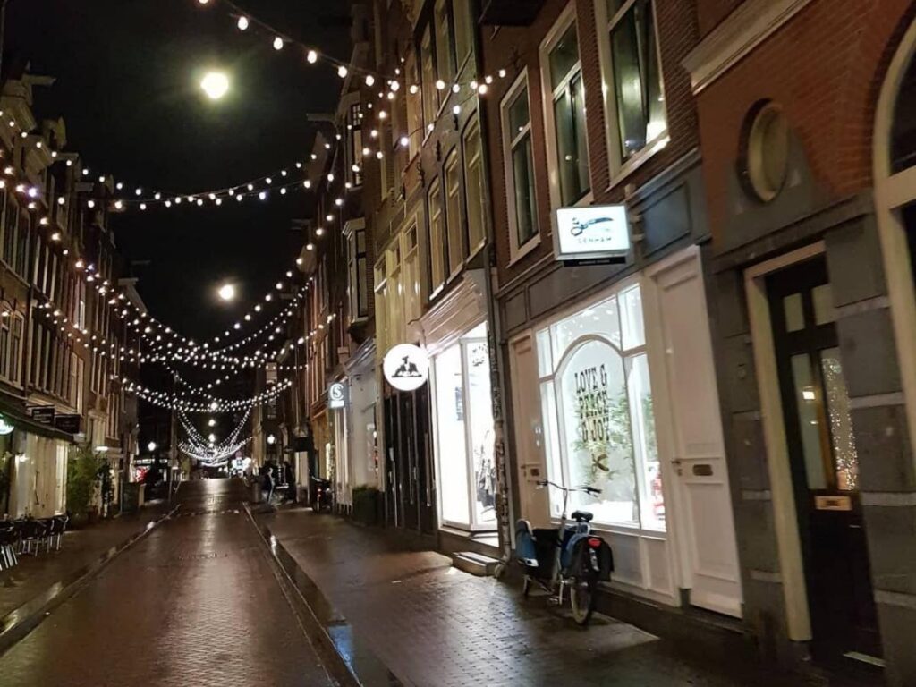 Boutique shop windows and pedestrians along De 9 Straatjes shopping streets