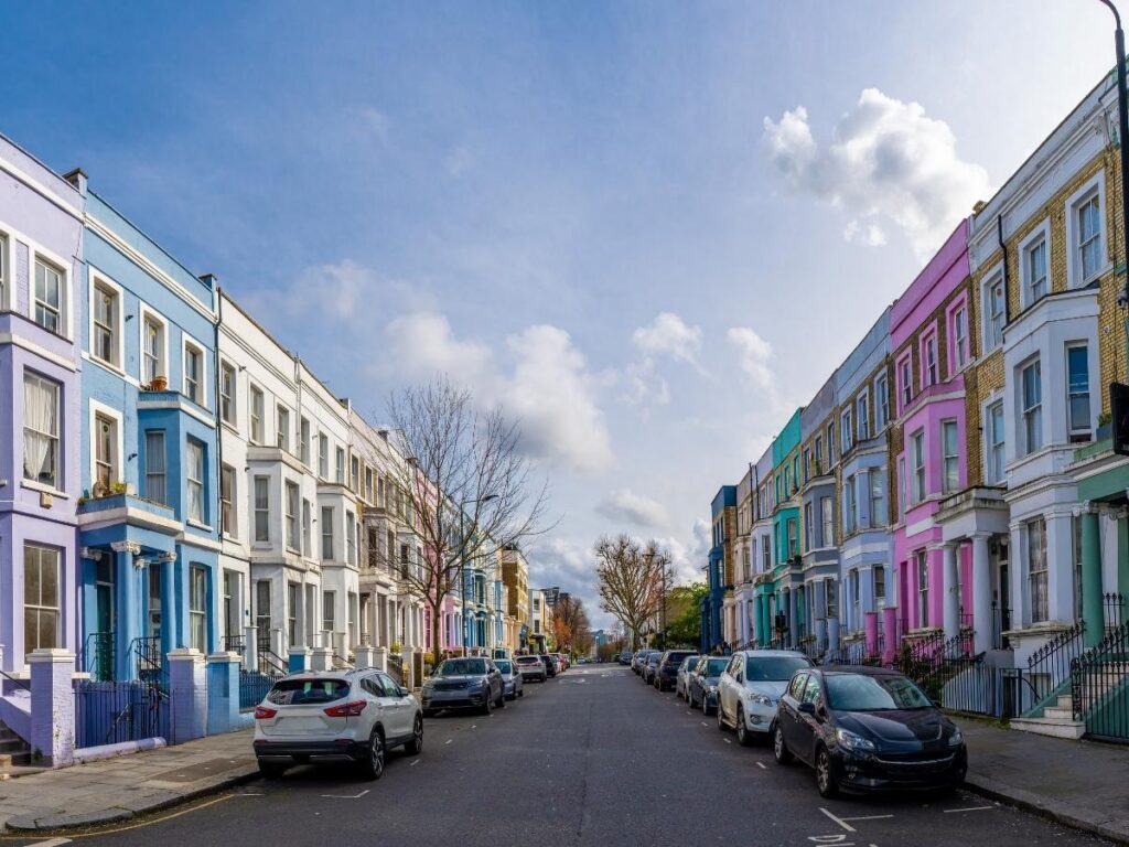 Row of pastel-colored houses on a quiet street in Notting Hill, London
