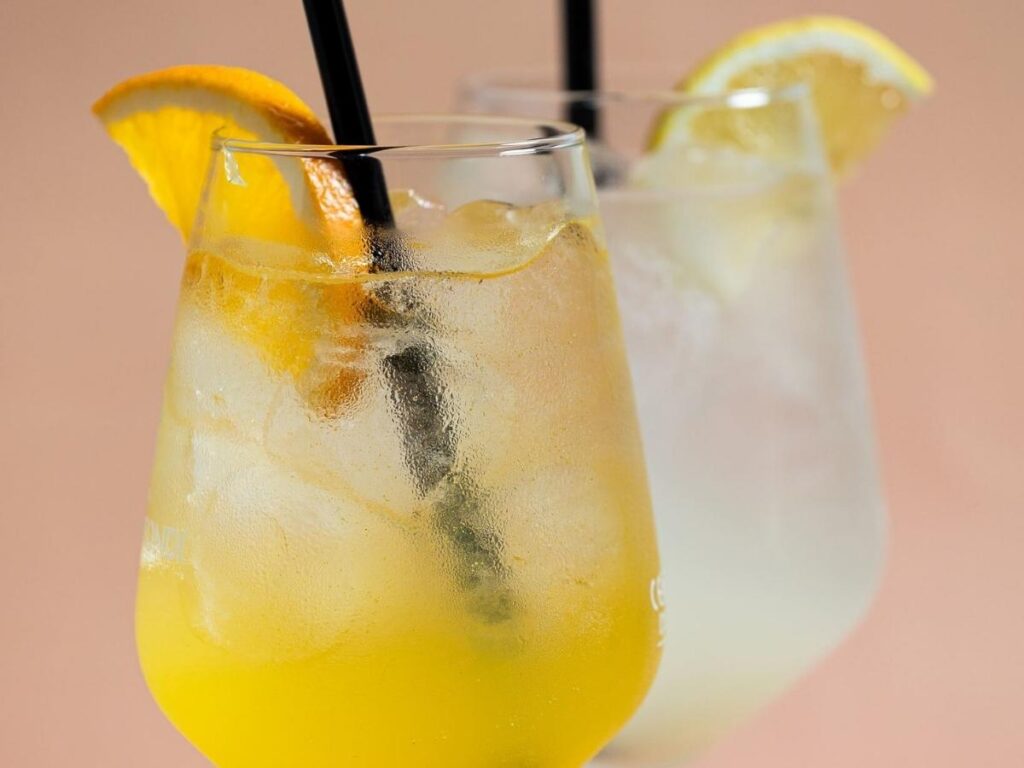 Aperol spritz and snacks on a terrace table overlooking Palermo’s rooftops at golden hour