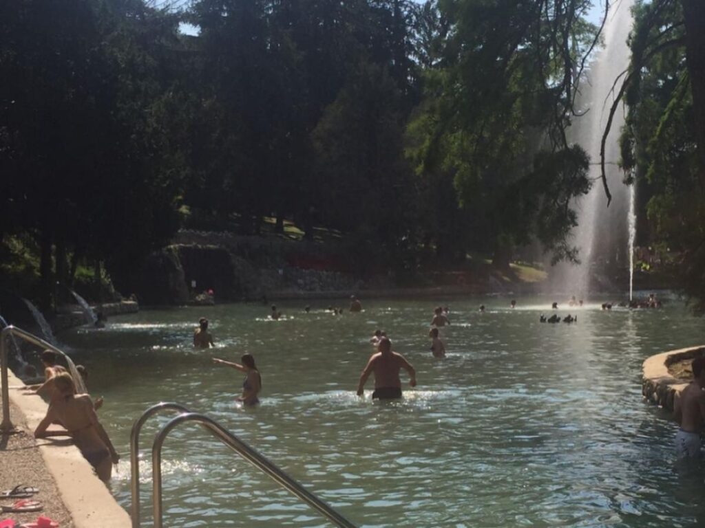 Family relaxing in thermal pools at Parco Termale di Colà surrounded by greenery