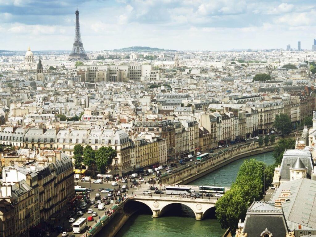 Paris rooftops and wrought-iron balcony view from a central hotel room
