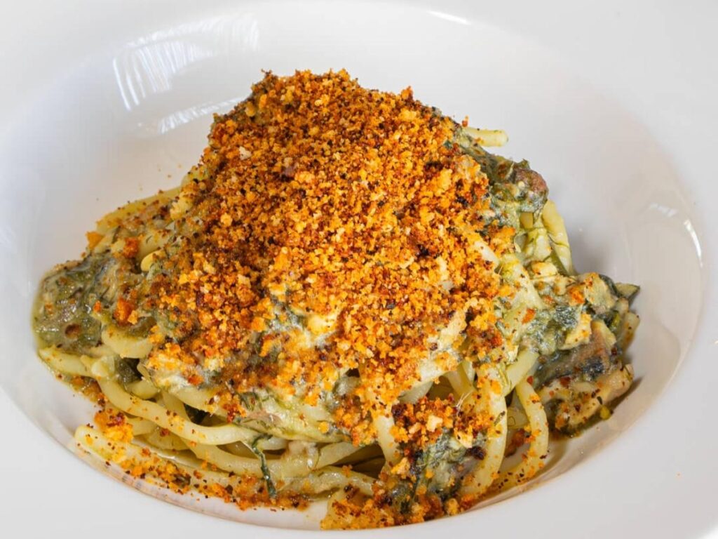 Traditional Sicilian pasta con le sarde with fennel, pine nuts, and raisins at a Palermo trattoria