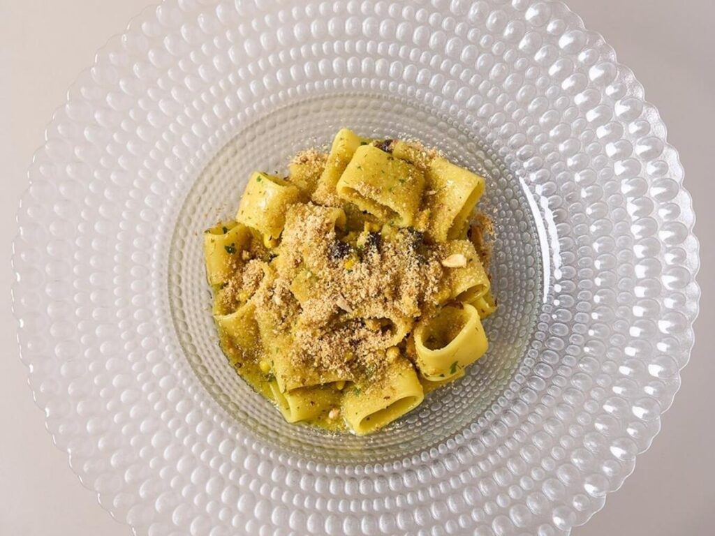 Rustic plate of pasta con mollica with toasted breadcrumbs and a drizzle of olive oil.