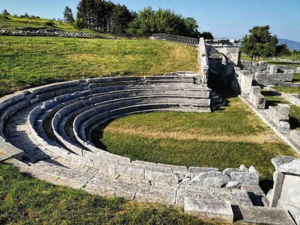 Stone seats of the Samnite theater at Pietrabbondante with sweeping mountain views beyond.