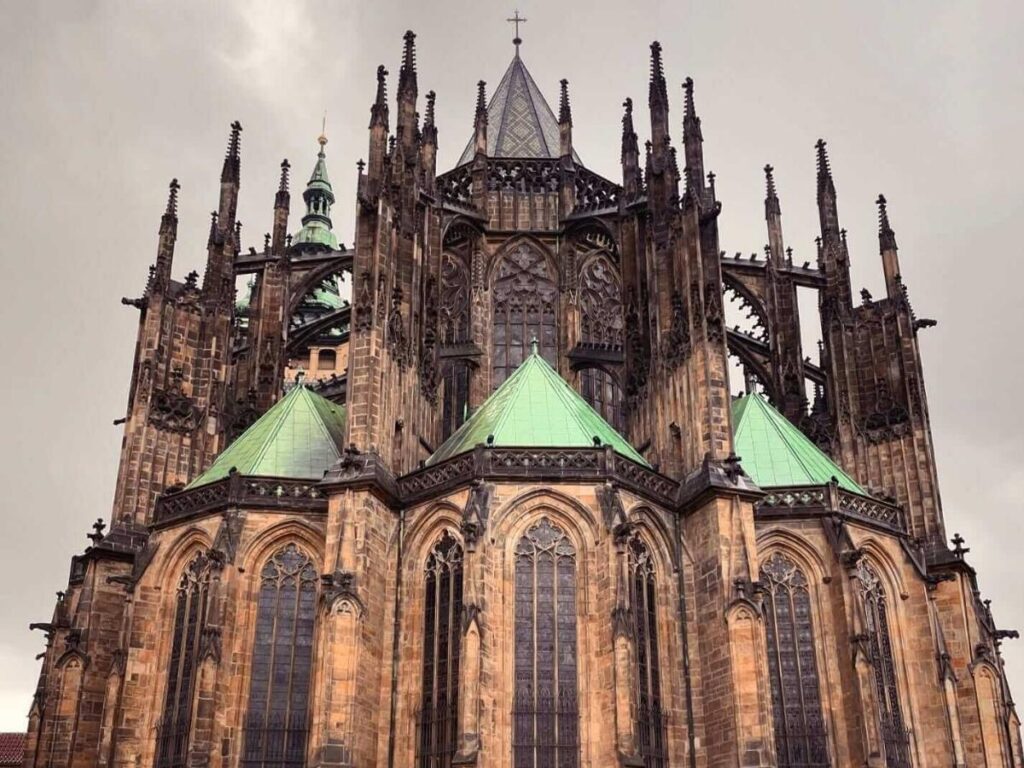 View from Prague Castle terraces showing St. Vitus Cathedral and red tile rooftops across the city.