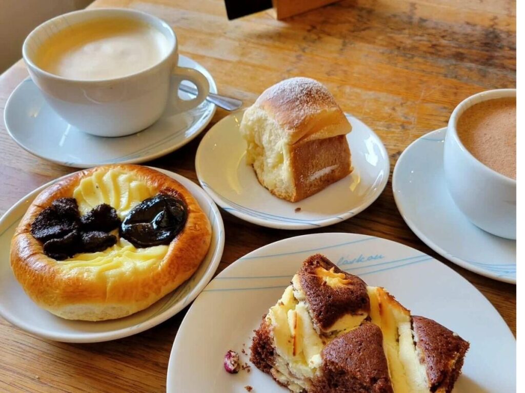 Warm koláč pastry and espresso on a café table, sunlight through the window, Prague morning scene.