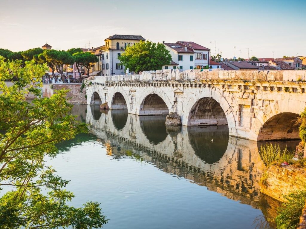 Ponte di Tiberio reflected in the Marecchia river at dawn, Rimini.