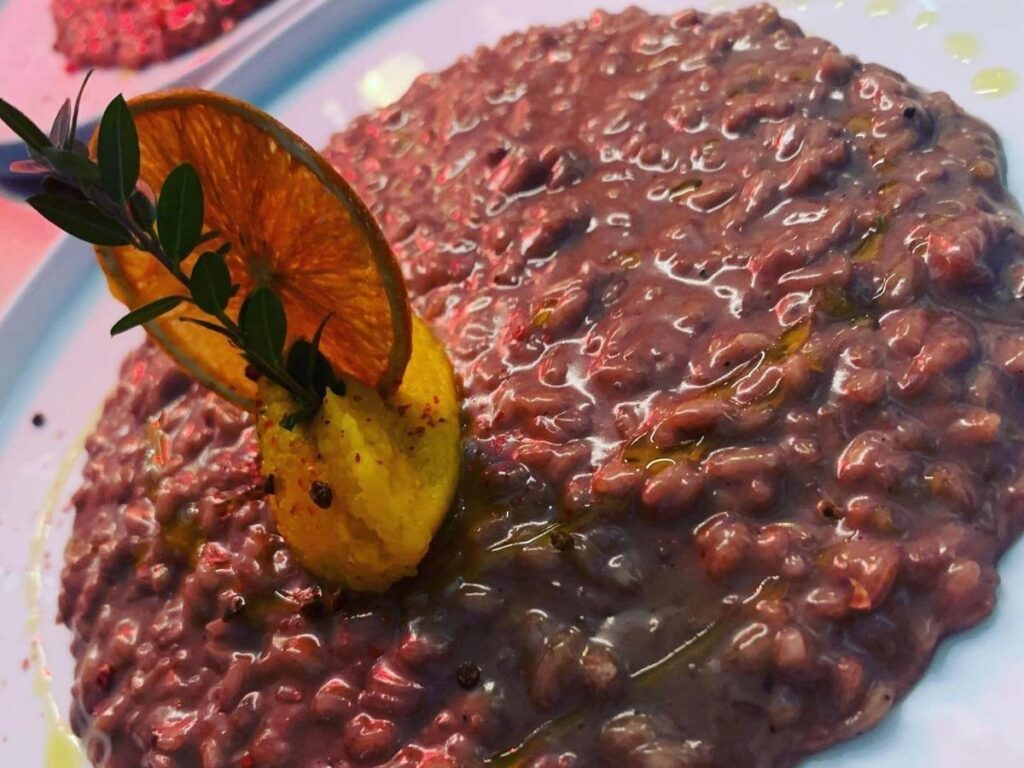 “Traditional risotto all’Amarone served in a rustic trattoria in Verona, Italy.”