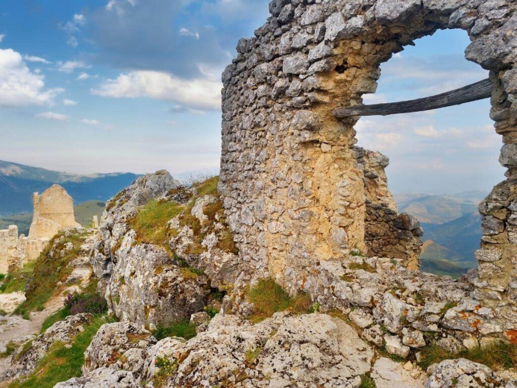 Ancient stone fortress ruins perched on a ridge with sweeping valley views, early morning light