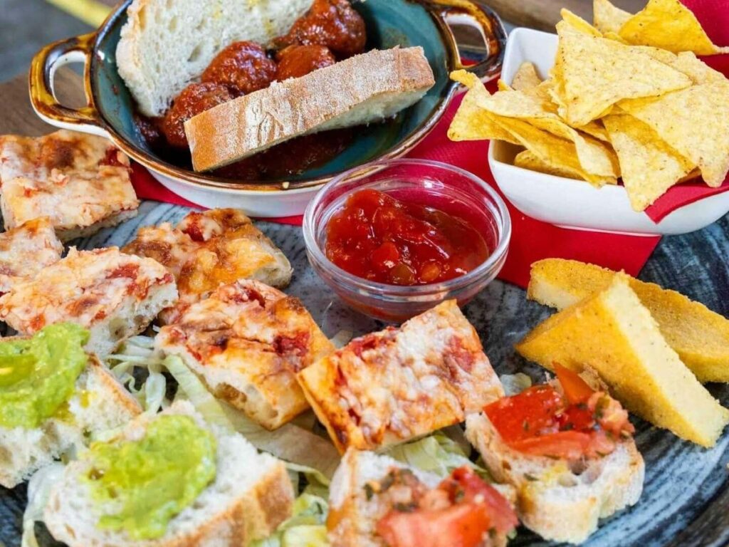 Aperitivo spread on a crowded outdoor table in San Salvario, Turin.