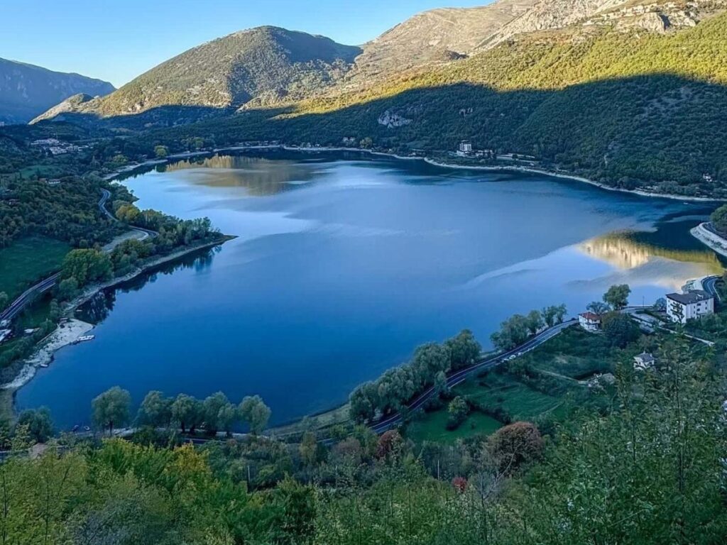 Panoramic view of Scanno village above the heart-shaped lake, narrow cobbled streets visible along the hillside