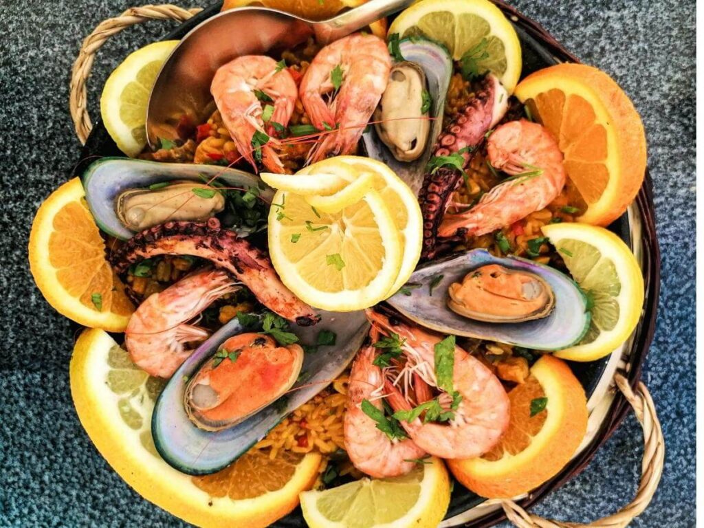 Grilled sardines and lemon wedges served at a small Lisbon tasca with a glass of vinho verde